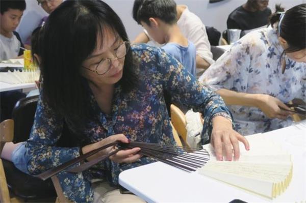 中國制扇工藝大師、蘇州制扇技藝傳承人盛春帶領中外友人學制扇